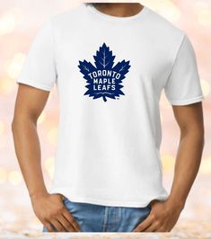 This AWESOME Toronto Maple Leafs t shirt is hand pressed with care. All of our items are hand made to order, using premium quality heat press vinyl, on super soft Gildan shirts, using 100% cotton and unisex sizing.    Check out the colour chart in the photo section we have done this t shirt on white so that it shows up really well, and the size chart to make sure you have the size you need. This t shirt for Toronto Maple Leafs is sure to become your new favourite graphic t shirts. Great for yourself or as a gift. If you do not see the size, colour or brand of t shirt you would prefer reach out to us and we will do our best to accommodate you. We also offer custom orders, so if you have a great idea for a design, get in touch and we'll see what we can do! Thanks for stopping by Blended and Cotton T-shirt With Sublimation Print For Fans, Sports Fan T-shirt With Screen Print And Crew Neck, Fan Apparel Cotton T-shirt With Sublimation Print, Cotton Fan Apparel T-shirt With Sublimation Print, Cotton Sublimation Print Fan Apparel T-shirt, Crew Neck Shirt With Screen Print For Fans, Sports Fan T-shirt With Screen Print, Crew Neck, Sports Fan White T-shirt For Fan Merchandise, Pre-shrunk Cotton Sports Fan T-shirt