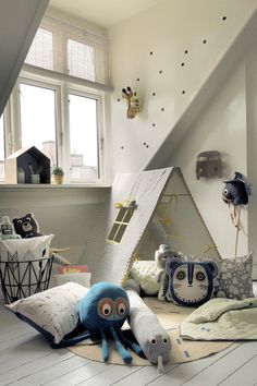 a room with stuffed animals and pillows on the floor