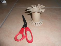 a pair of scissors sitting on top of a table next to a toilet paper roll