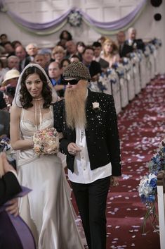 a bride and groom walking down the aisle