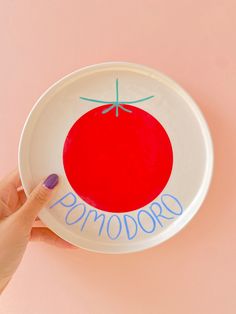 a hand is holding a plate with a tomato on it that says,'tomorrow '