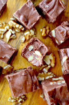 several pieces of chocolate and nuts on a wooden table