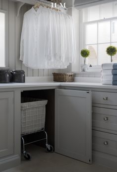 a laundry room with clothes hanging on the rack