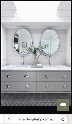 a bathroom with two sinks and mirrors on the wall