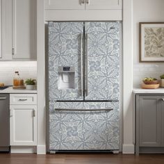 a refrigerator in a kitchen with blue and white wallpaper on the door, cabinets and drawers