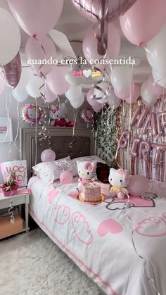 hello kitty themed birthday party with pink and white balloons hanging from the ceiling over a bed