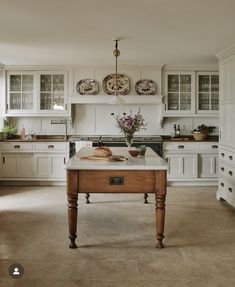 a kitchen with an island in the middle of it and two plates hanging from the ceiling