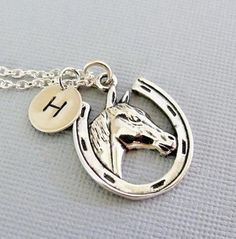 "A horse lovers necklace... This detailed solid sterling silver horse/horseshoe charm dangles from a sterling silver chain. A small round tag/charm sways alongside with a hand stamped initial. The horse/horseshoe charm measures 20 x 13.5mm (13/16\" x 9/16\") and the small hand stamped initial tag measures 9mm (3/8\"). The chain comes in a (14\", child\"s length), 16\", 18\" and 20\" inch lengths to choose from during checkout. If you have any questions, please do not hesitate to contact me. Than Silver Horseshoe Charms Jewelry, Adjustable Sterling Silver Horse Design Jewelry, Silver Horseshoe Necklace For Gift, Personalized Silver Horseshoe Jewelry, Silver Horseshoe Jewelry Gift, Silver Horseshoe Necklace Nickel Free, Nickel-free Silver Horseshoe Necklace, Silver Jewelry With Horse Design In Round Pendant, Silver Sterling Silver Jewelry For Shows