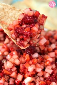 a spoon full of food that is being held over the top of some kind of bowl