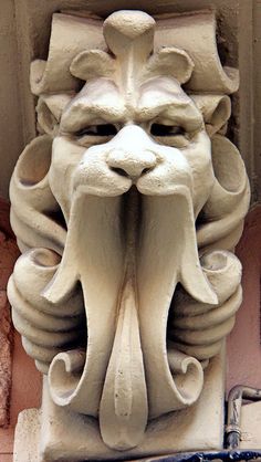 a close up of a face on the side of a building with an animal's head