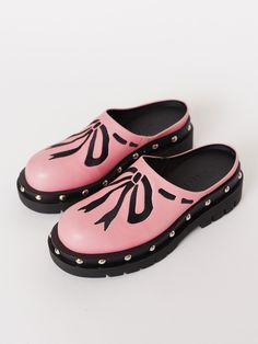 Plumbers are big fans of clogs, wonder why…Your new summer shoe has finally arrived! In pink, these slip-on clog shoes are made from 100% vegan leather with a contrasting cleated rubber sole that has a slight heel, and stud detailing all the way around. They have a side gusset which helps give ease and comfortability to the wear of the shoe. Across the body of the shoe is an embroidered bow detailing in a contrasting black. Spring Slip-on Clogs With Studded Rubber Outsoles, Trendy Clogs With Lug Sole And Round Toe, Trendy Slip-on Clogs With Lug Sole, Pink Rubber Sole Slip-ons For Spring, Spring Flat Clogs With Rubber Sole, Pink Round Toe Clogs For Spring, Trendy Slip-on Clogs With Round Toe, Pink Rubber Sole Clogs For Spring, Pink Spring Clogs With Rubber Sole