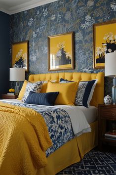 a bedroom with blue walls and yellow bedding in the center, along with two framed pictures on the wall