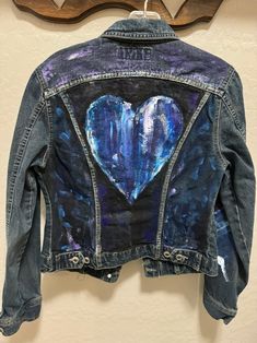 a denim jacket with a heart painted on it