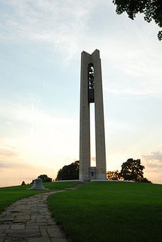 there is a tall monument in the middle of a grassy field with a path leading up to it