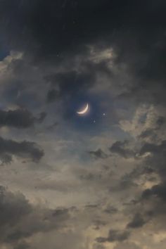 the moon is in the cloudy sky with dark clouds