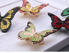 four different colored butterflies sitting on top of each other