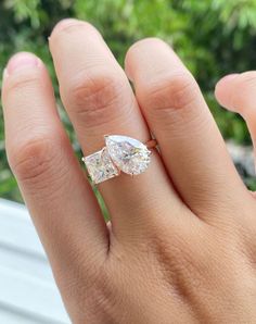 a woman's hand with two engagement rings on it