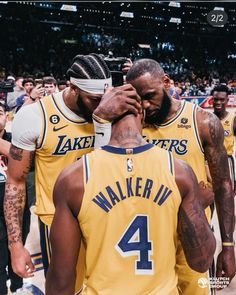 two basketball players standing next to each other with their hands on their faces in front of the crowd