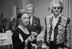 black and white photograph of two women standing next to each other in front of a table