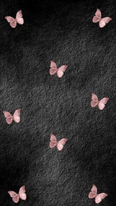 some pink butterflies flying in the air on a black and white background with space for text