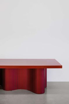 a red table sitting on top of a cement floor