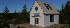 a small white house sitting on top of a wooden platform