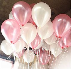 a bunch of pink and white balloons in a vase