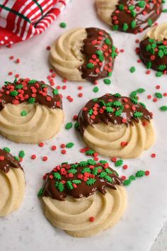 cookies decorated with chocolate and sprinkles on a sheet of white parchment paper