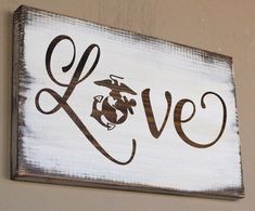 a wooden sign with the word love written in cursive writing and a marine animal on it