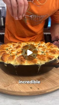 a person holding a pot pie on top of a cutting board