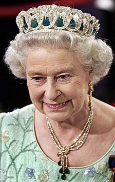 an older woman wearing a tiara with pearls and emeralds on it's head