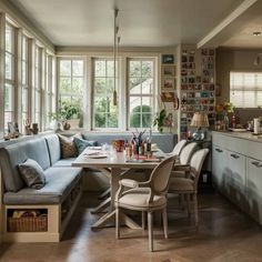 a dining room table with chairs and a bench in front of it next to windows