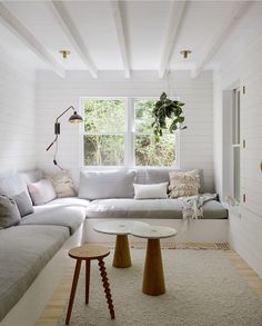 a living room with white walls and wood flooring on the ceiling is filled with furniture