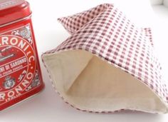 a red and white checkered napkin next to an old fashioned canister with the lid open