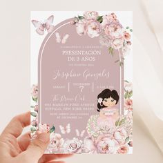 a person holding up a pink card with flowers on it