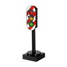 a traffic light that is on top of a black stand with red and white stripes