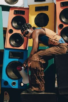 a man standing in front of speakers with his hand on the ground next to it