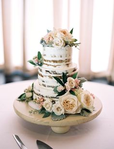 a white wedding cake with flowers on top