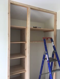 two ladders are in front of a bookcase that is being built into the wall