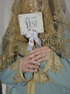 a woman wearing a veil and holding a sign with the word yes written on it