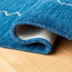 a blue rug with white stars on it and a wooden floor in front of it