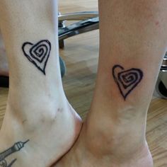 two people with matching tattoos on their feet, one has a heart and the other has an eiffel tower