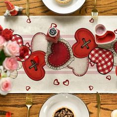 the table is set for valentine's day with heart shaped plates and silverware