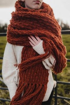 a woman wearing a red knitted scarf