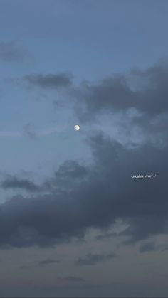 the moon is seen through some dark clouds