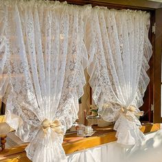 the window is decorated with white lace and bows