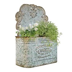 an old metal planter with flowers and herbs in it is displayed on a white background