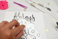 someone is drawing on paper with scissors and other crafting supplies