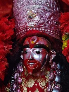 a close up of a statue with red paint on it's face and head