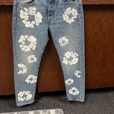 a pair of blue jeans with white flowers on them